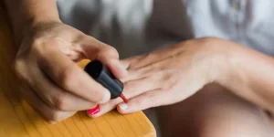 Latin adult woman painting finger nails at home in Mexico Latin America