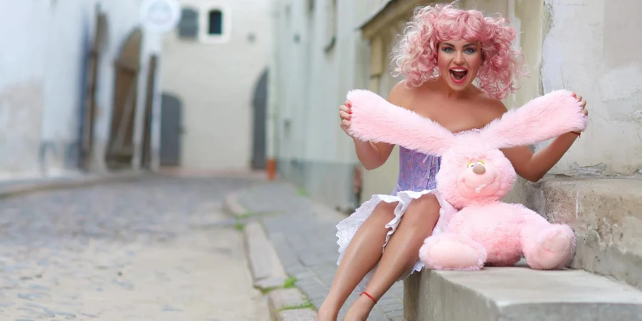 Woman Wearing Purple and Pink Dress Holding Rabbit Plush Toy