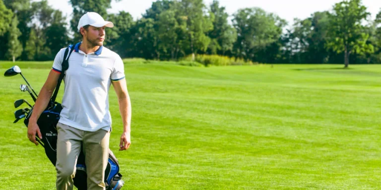 young male golfer carries a bag of golf clubs