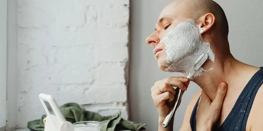 A Man Shaving his Neck with a Razor by Karolina Kaboompics