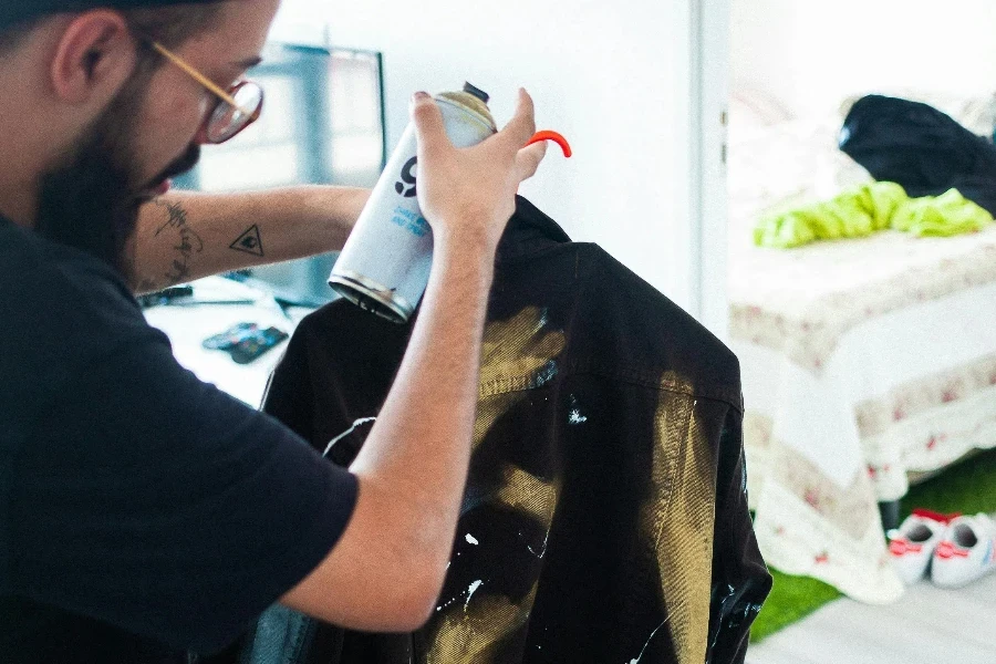 A Man Using s pray Paint on a Jacket