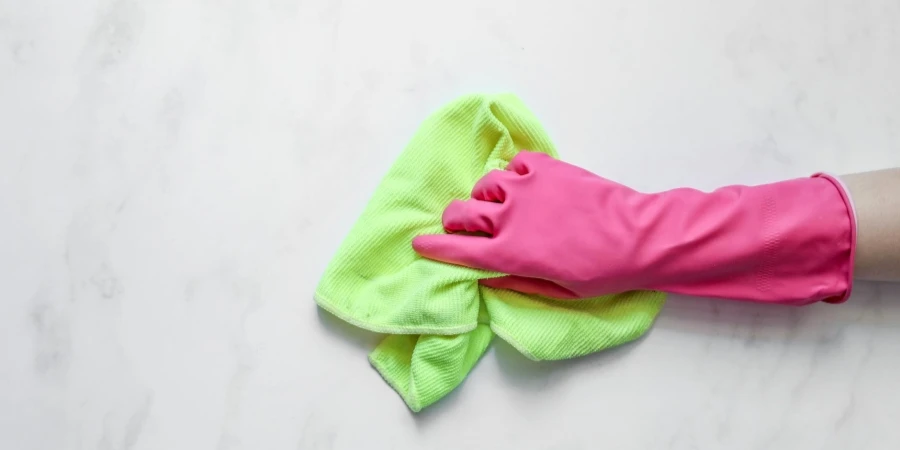 A Person Using Rubber Glove and Cleaning Cloth