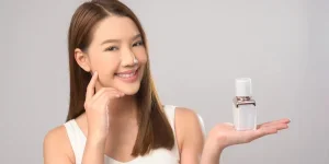 A Portrait of beautiful asian woman holding moisturizer cream over