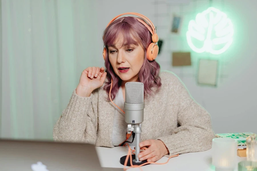 A Woman Talking on a Microphone while Wearing a Headphone