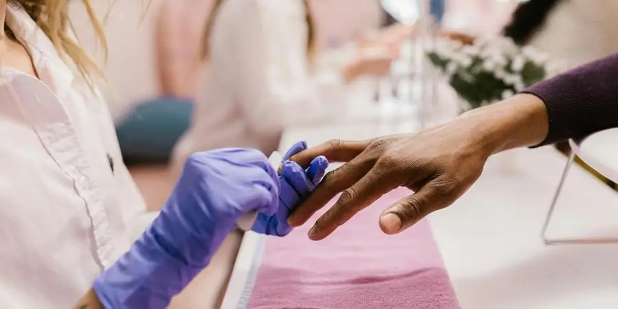 A Woman using a Nail File while Polishing Nails of her Client by RDNE Stock project