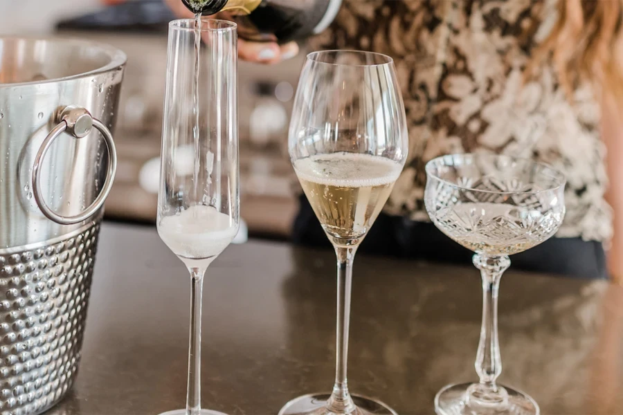 A champagne flute next to other drink glasses