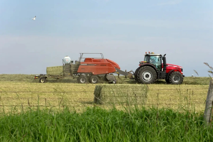 A farmer baling hay with a large square baler