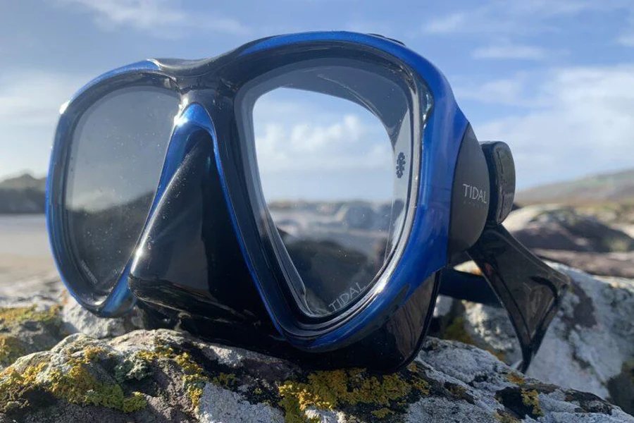 A framed diving mask on some rocks