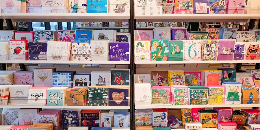 A large selection of birthday cards and other greetings cards on display and for sale in the store.