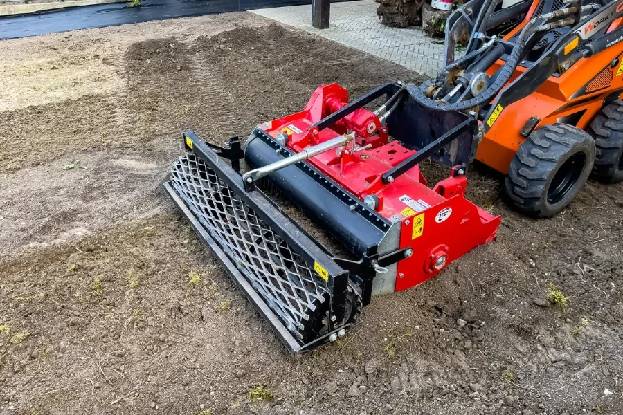 A municipal worker sows a lawn using a Boxer mechanical seeder