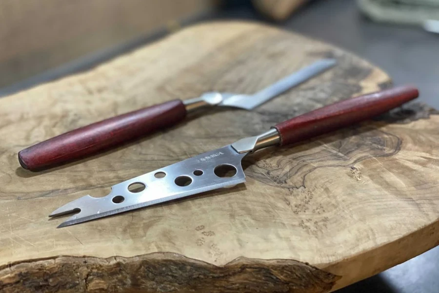 A pronged cheese knife next to an offset knife