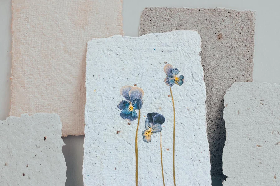 A sheet of handmade paper with seeds and flowers . Reuse of materials.