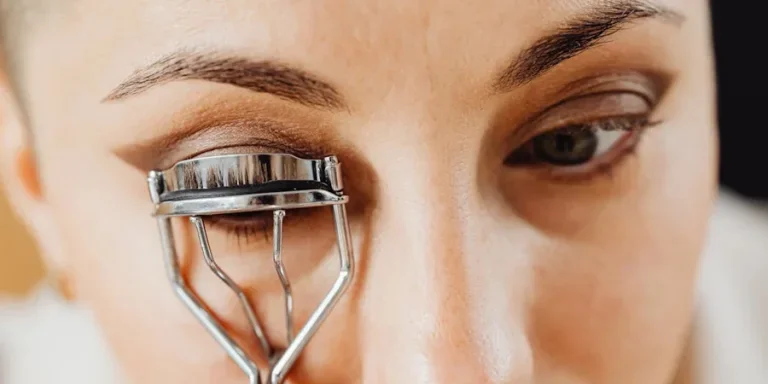 A woman curling her eyelashes