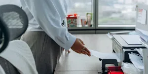 A woman printing a paper in an office
