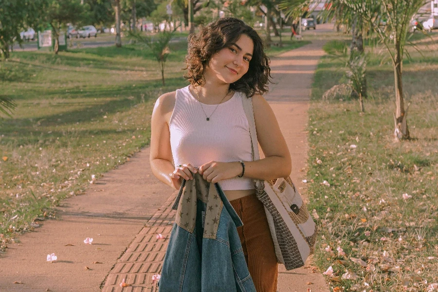 A woman walking down a path with a bag