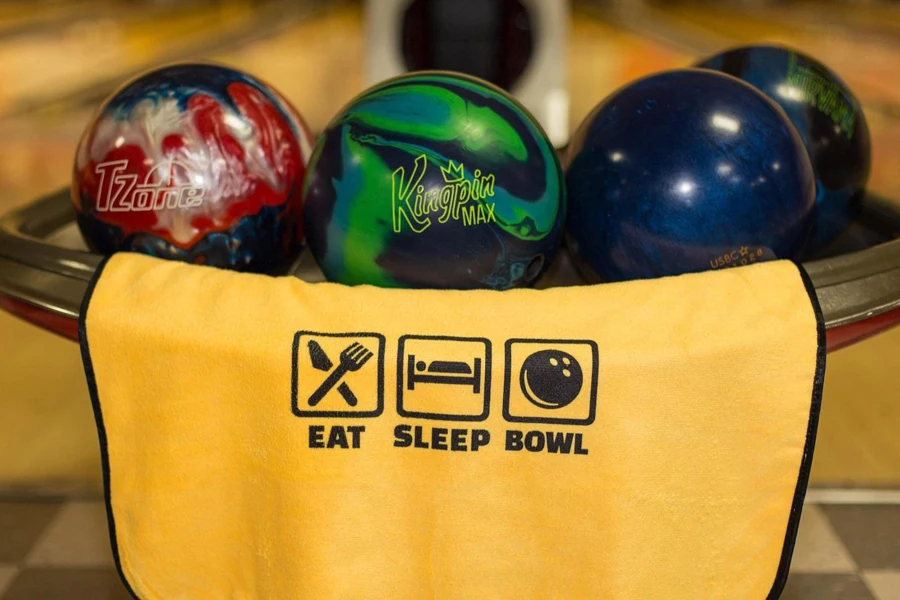 A yellow shammy towel near some bowling balls