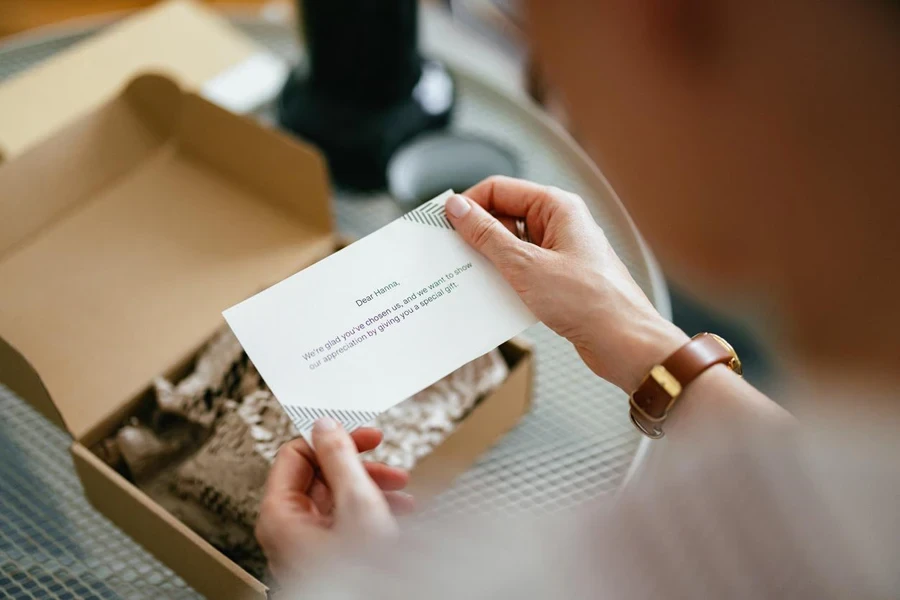 Anonymous woman sitting and in her hands holding a paper note with a written message on it. 