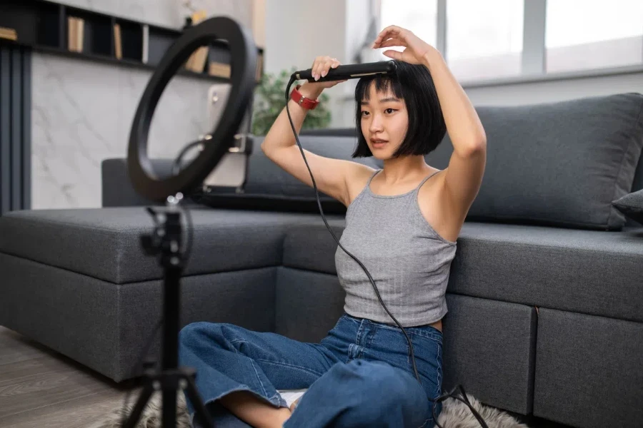 Asian beauty vlogger curling her bangs with a curler 