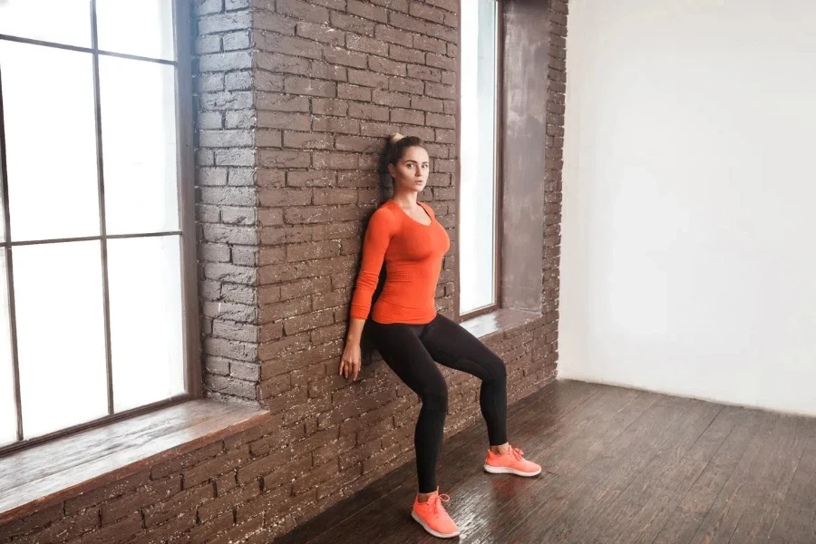 Balancing exercise. Activity woman looking at camera and doing workout. Studio shot