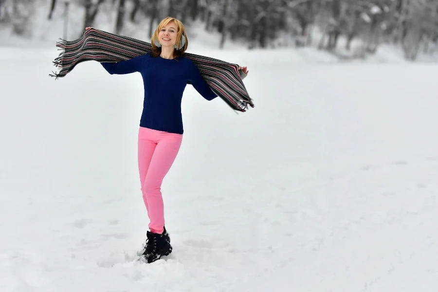 Beautiful Woman Standing in the Snow with Outstretched Arms Holding a Shawl 