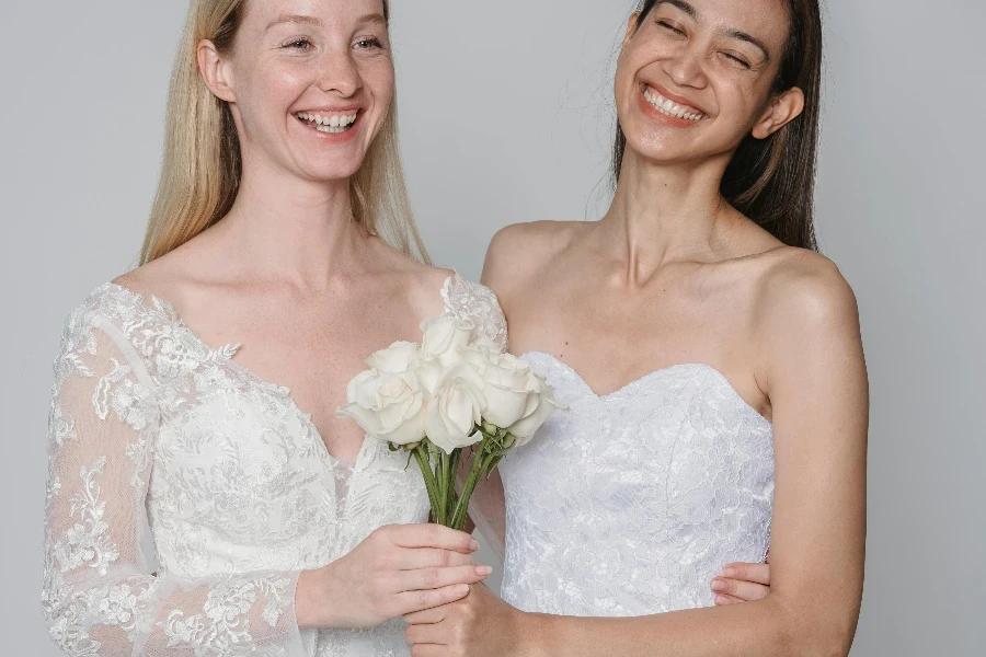 Beautiful Women in Wedding Dresses Holding a Bouquet of White Roses