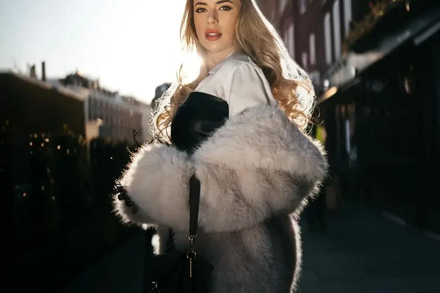 Blonde Woman Wearing Fur Coat in Sunlight by Andras Stefuca