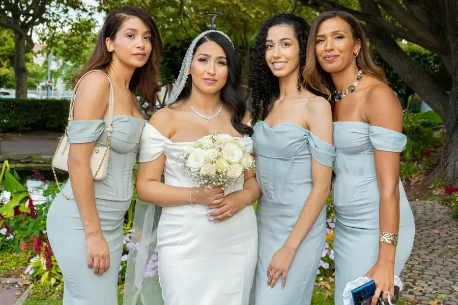 Bridesmaids in blue dresses pose for a photo by UMA Group