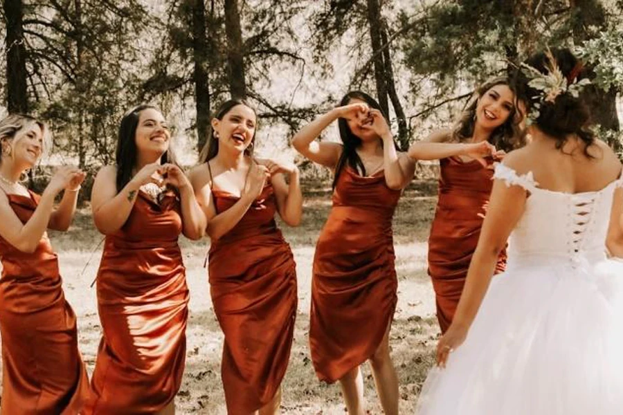 Burnt orange satin bridesmaid dresses with asymmetrical hem