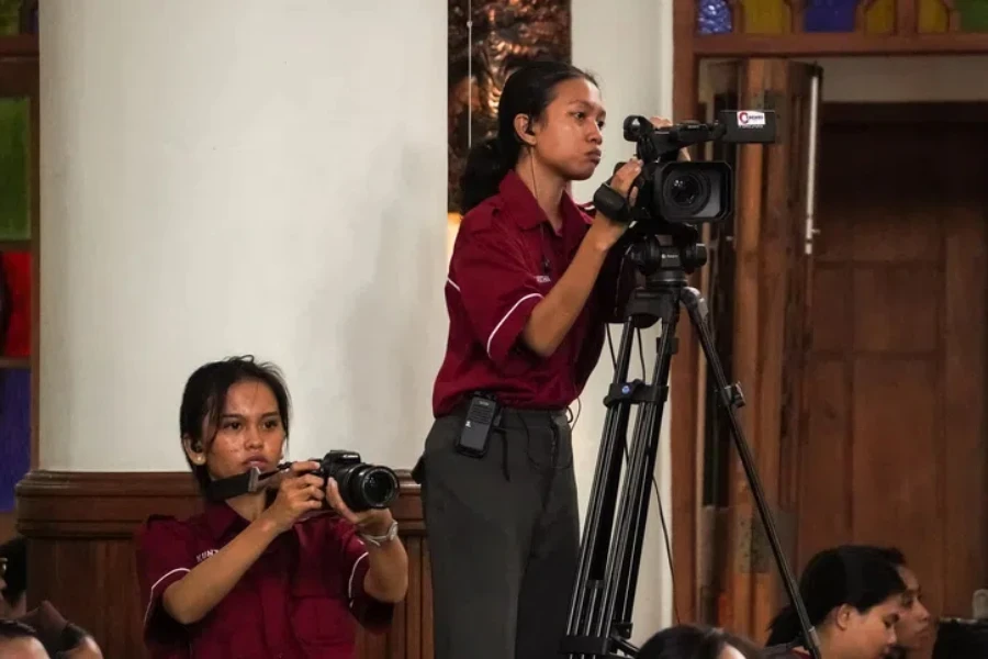 Cameraman video camera operator is taking a documentary film of the Catholic Eucharistic Celebration