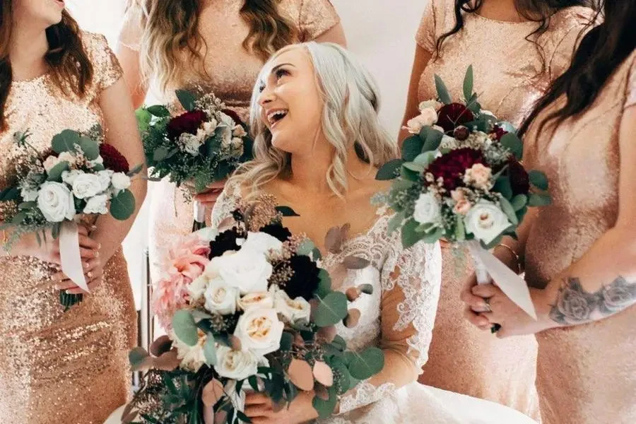 Cheerful fiancee and bridesmaids with beautiful bouquets by Kayla Renee