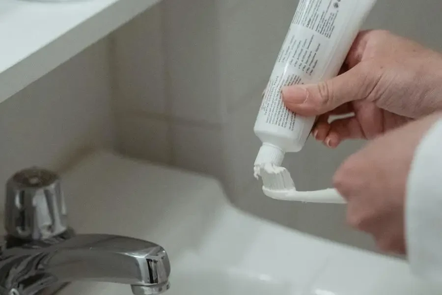 Close-up of Person Brushing Teeth with Toothpaste by Miriam Alonso