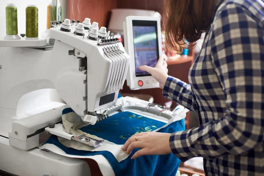 Close-up of woman working on modern computerized specially engineered embroidery machine