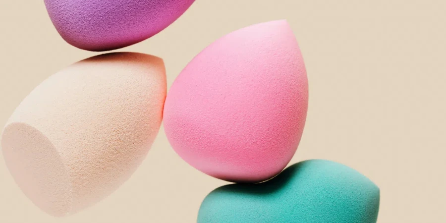 Colored cosmetic beauty blender sponges on nude colored background