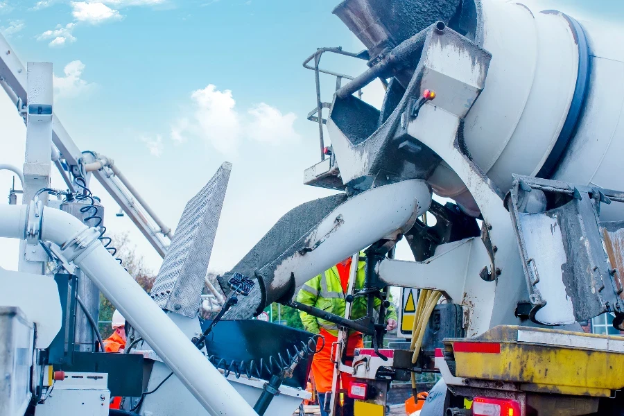 Concrete is offloaded from a concrete mixer into a concrete pump.