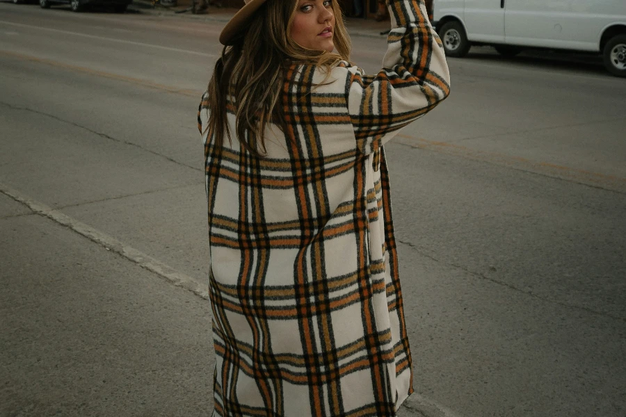 a woman is standing wearing a peacoat