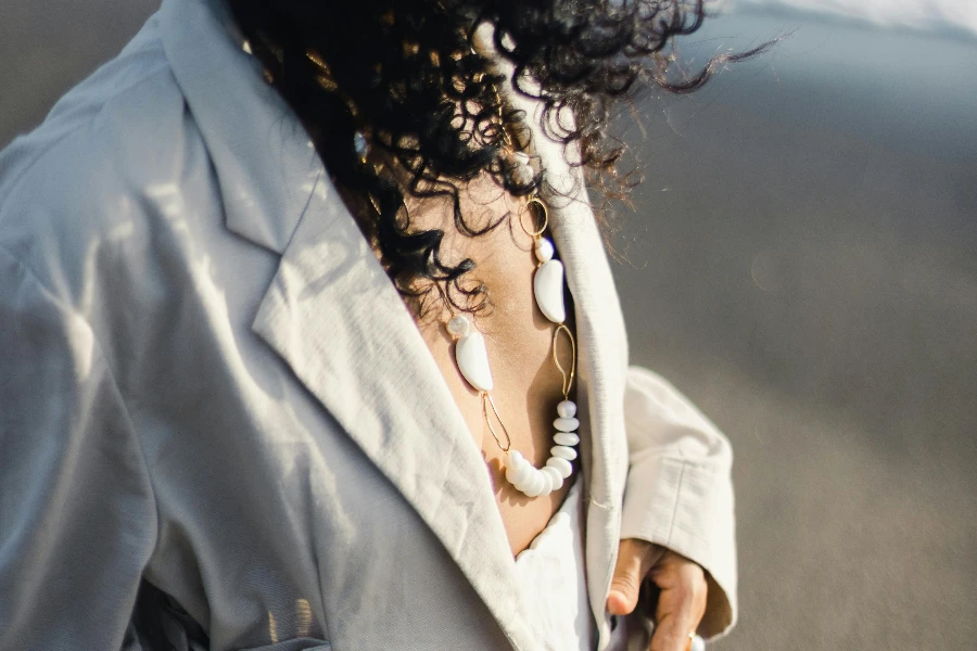 Crop unrecognizable stylish woman with accessories on sea shore