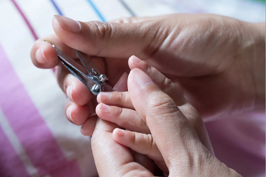 Cutting nails to a newborn baby a little mother care