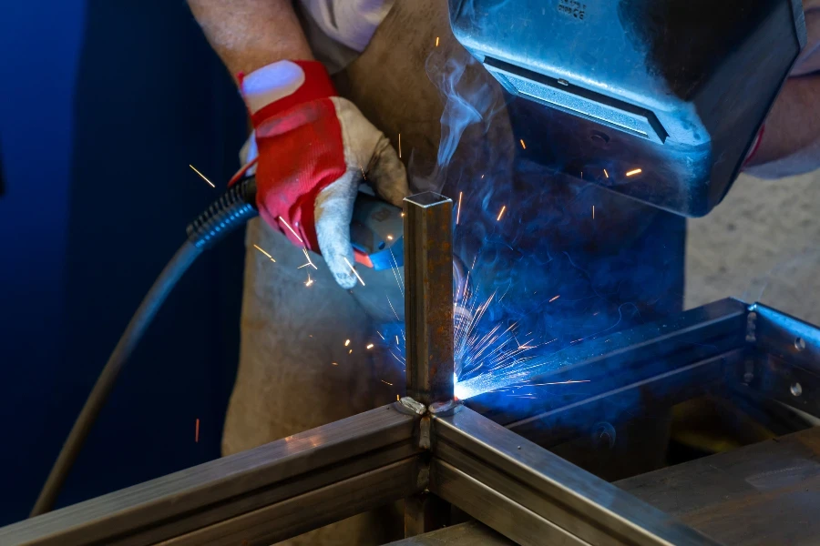 Detail of a man welding steel frames in a forgery and metal works workshop