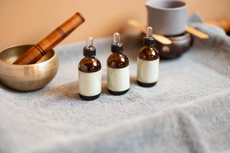 Essential oil in jars and other props for massage on a towel