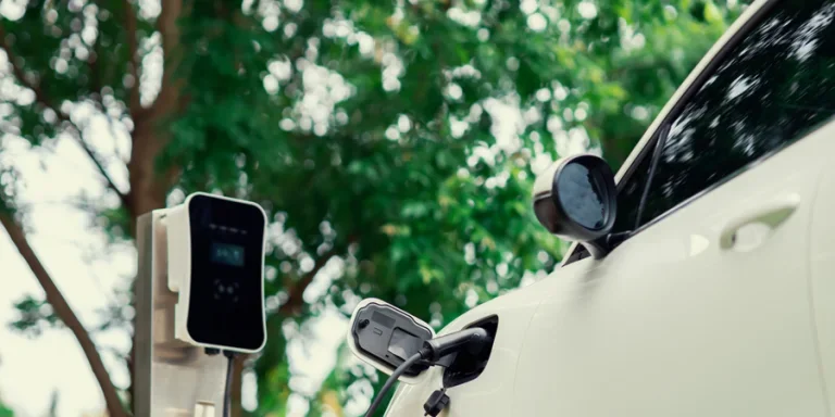 Фокус крупным планом: электромобиль и зарядное устройство с размытым фоном для прогрессивной концепции