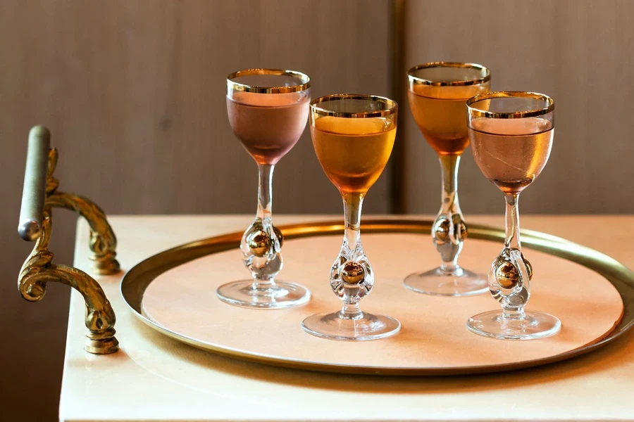 Four filled cordial glasses on a tray