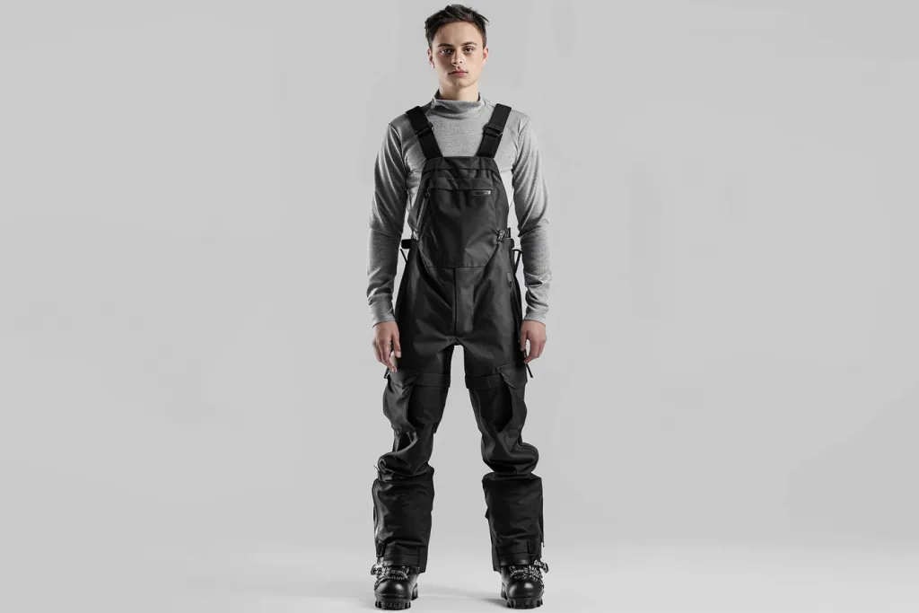 Generate an image of the model wearing black ski overalls