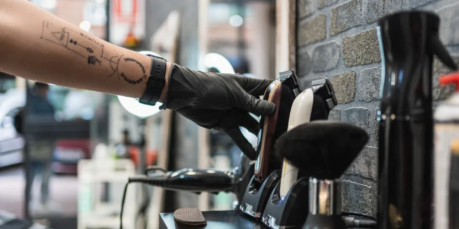 Girl hairdresser makes a haircut to a young guy using a hair clipper in a barbershop