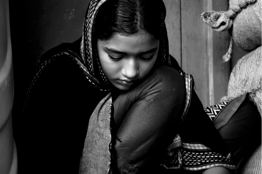 Girl in Black Head Scarf Sitting on the Floor