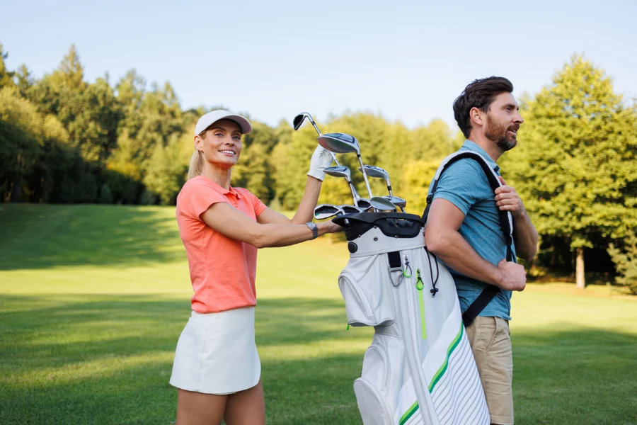 Golf Partnerships Woman Picks Club from Companion's Bag