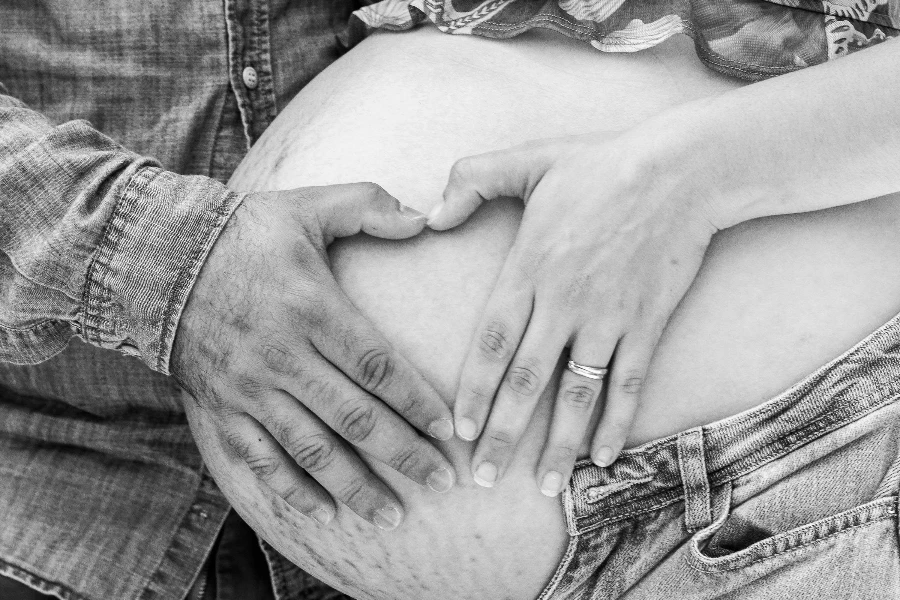 Grayscale Photo of Hand Touching the Pregnant Woman‘s Tummy