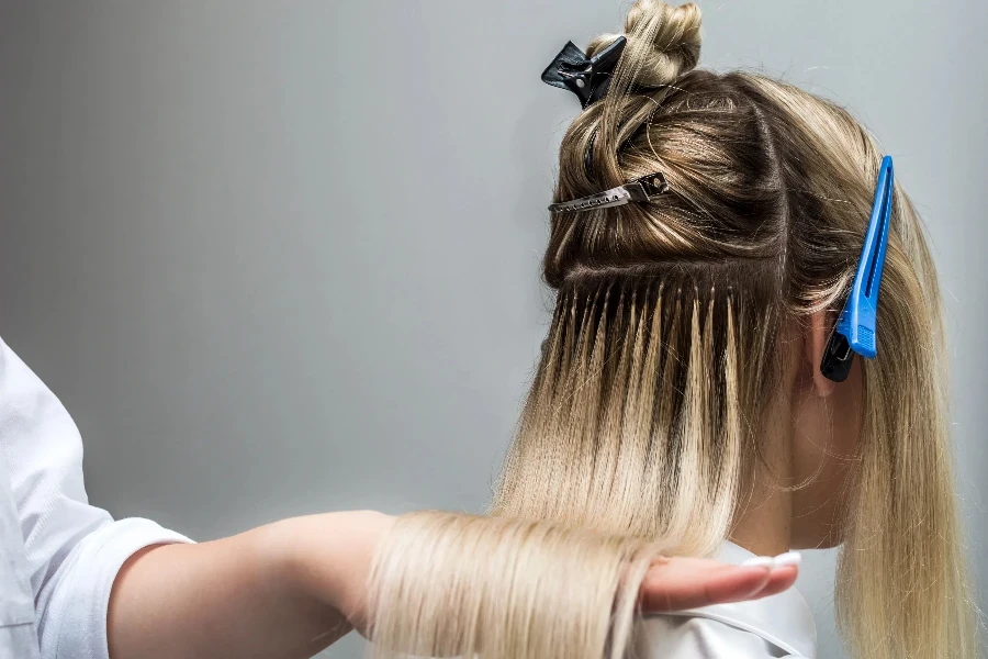 Hair extensions to a client close up in a beauty salon