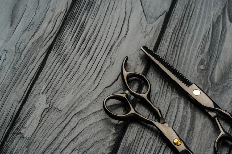 Hairdressing scissors on black wooden background close up photo