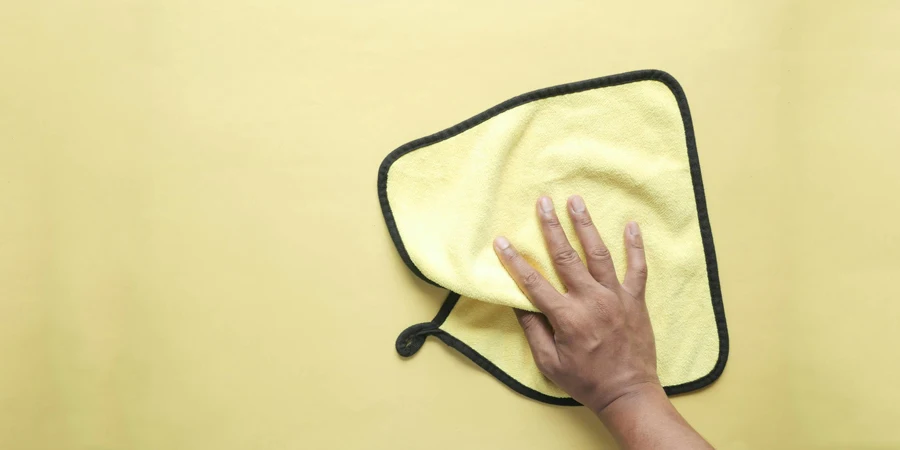 Hand Holding a Yellow Microfiber Towel