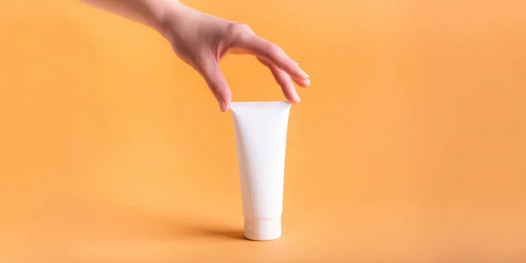 Hand reaching down to grab a white label bottle of moisturizer